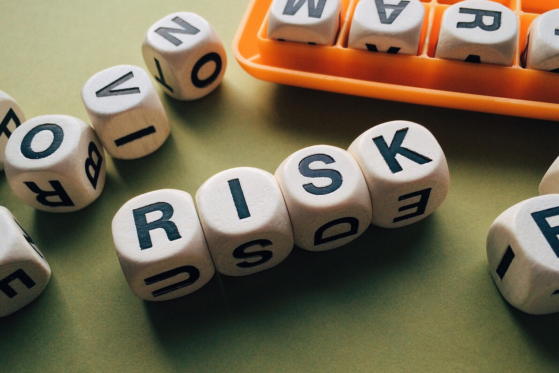 Dobbelstenen met ‘risk’ die onzekerheid en kans op financiële risico’s uitbeelden